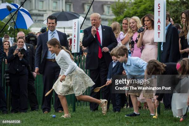 President Donald Trump, with first lady Melania Trump, their son Barron Trump, and members of the first family, blows a whistle to begin an Easter...