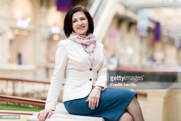 zakenvrouw 50 jaar oud in een witte jas - 50 54 years stockfoto's en -beelden