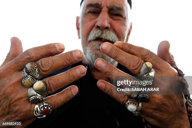 Shiite Muslim pilgrim shows his rings as he walks towards the shrine of Imam Musa al-Kadhim in Baghdad's northern district of Kadhimiya on April 18...