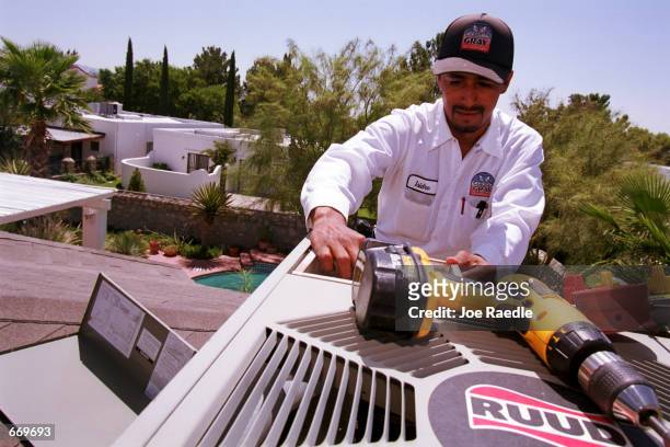 Isidro Lerma, a Gray Air Conditioning technician, works on a unit, July 20, 2000 in Santa Teresa, New Mexico. A heat wave that stretches from Arizona...