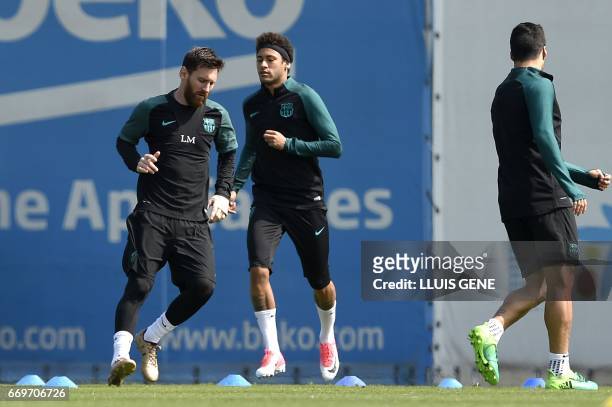 Barcelona's Argentinian forward Lionel Messi , Brazilian forward Neymar and Uruguayan forward Luis Suarez take part in a training session at the Joan...
