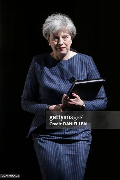 British Prime Minister Theresa May walks out of 10 Downing Street to make a statement to the media in central London on April 18, 2017. British Prime...