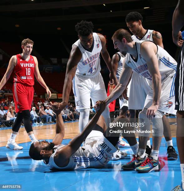 Dakari Johnson, Josh Huestis and Alex Caruso of the Oklahoma City Blue help their teammate Reggie Williams up off of the floor against the Rio Grande...