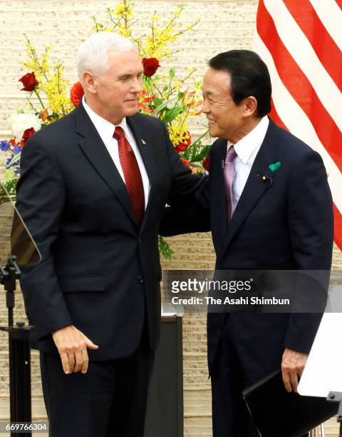 Vice President Mike Pence and Japanese Deputy Prime Minister and Finance Minister Taro Aso shake hands during a joint press conference following...