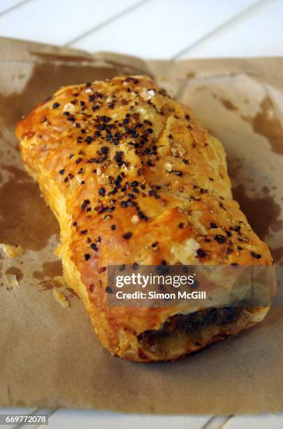 snack of a take away pork sausage roll - sausage roll stock-fotos und bilder