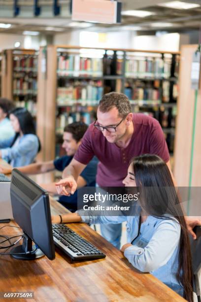 teacher helping student at the library - librarian stock pictures, royalty-free photos & images