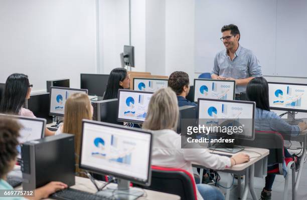 teacher giving an it class at school to a group of students - online class imagens e fotografias de stock