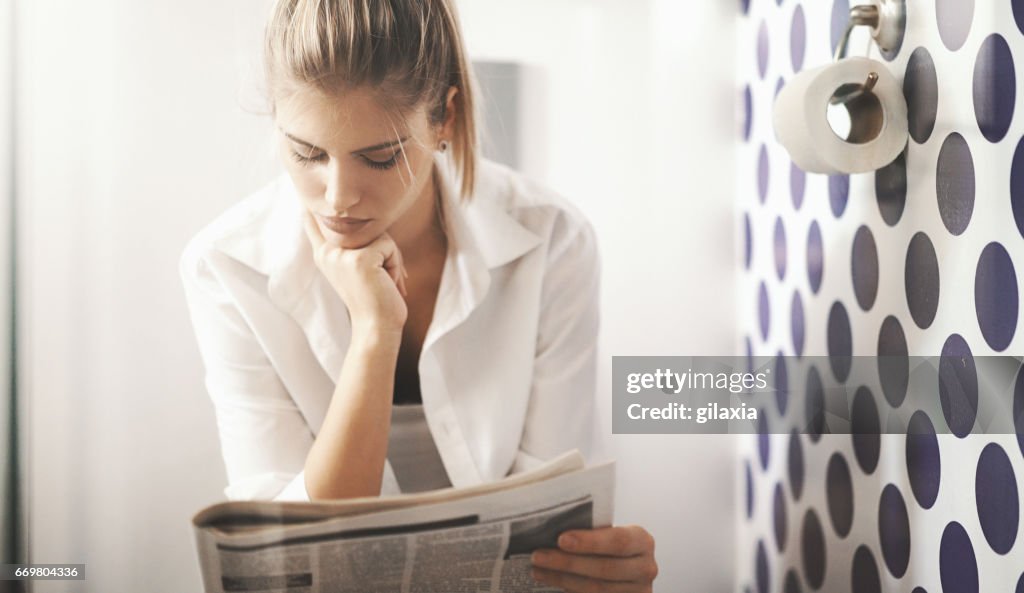 Reading newspapers in toilet.