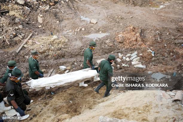 Sri Lankan military rescue workers recover the body of a child during a rescue operation at the site of a collapsed garbage dump in Colombo on April...