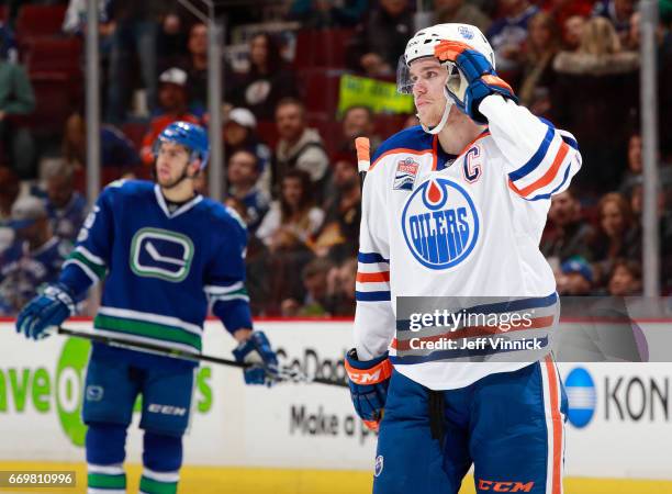 Connor McDavid of the Edmonton Oilers and Michael Chaput of the Vancouver Canucks skate up ice during their NHL game at Rogers Arena April 8, 2017 in...