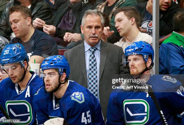 Head coach Willie Desjardins of the Vancouver Canucks looks on from the bench during their NHL game against the Edmonton Oilers at Rogers Arena April...