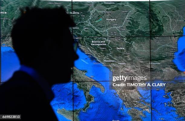 Man looks at a Google Earth map on a screen as Google Earth unveils the revamped version of the application April 18, 2017 at a event at New York's...