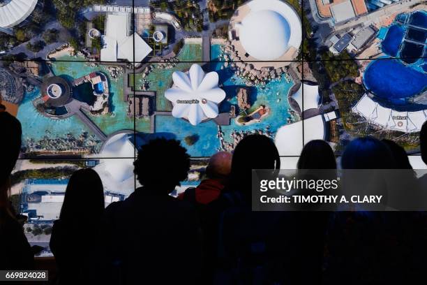 People look at Oceanografic Valencia Aquarium on Google Earth map on a screen as Google Earth unveils the revamped version of the application April...