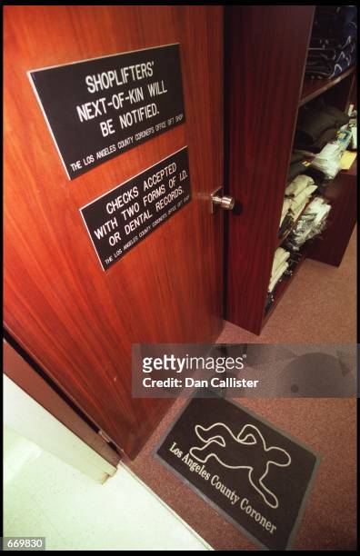 Two signs on the door of "Skeletons in the Closet," the Los Angeles County Coroners Gift Shop, reflect the black humor of the shop July 21, 2000 in...