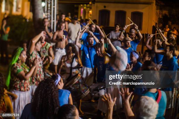 courtship of maracatu - traditional folk dance with african roots - with the batuki kianda group in ilhabela, brazil, on april 16, 2017, walking the streets of the historic city center. photos made with a tilt-shift lens. - africano stock pictures, royalty-free photos & images