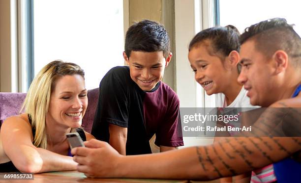 family uses mobile phone together - photohui stock pictures, royalty-free photos & images