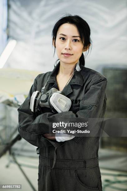 vrouwelijke nec technicus in een auto reparatiewerkplaats - overall stockfoto's en -beelden