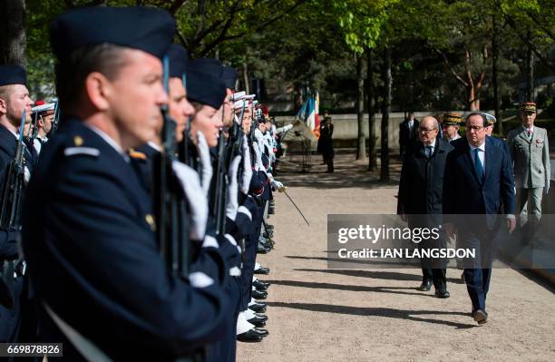 French President Francois Hollande and Defense Minister Jean-Yves Le Drian review troops as part of a ceremony for fallen French soldiers in overseas...