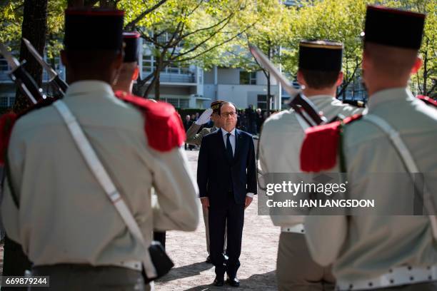 French President Francois Hollande reviews troops as part of a ceremony for fallen French soldiers in overseas military operations , in Parc Andre...