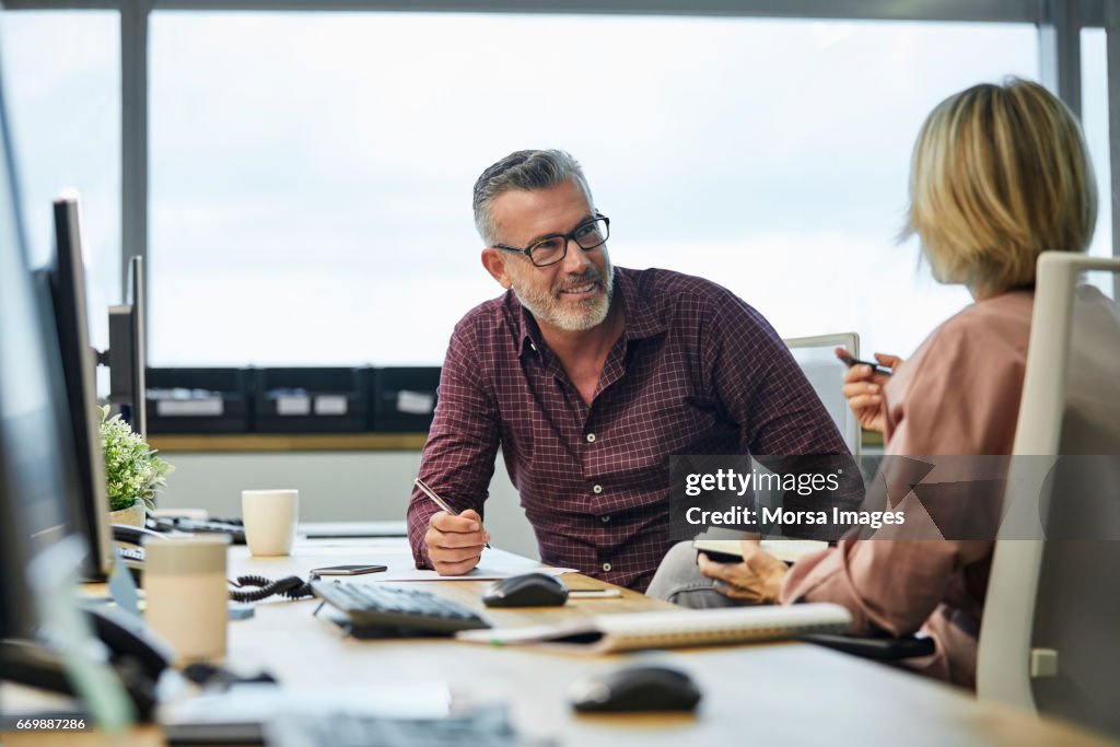 Zakenman communiceren met collega aan balie