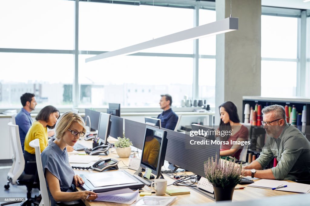 Mensen uit het bedrijfsleven werken bij "desk" door windows