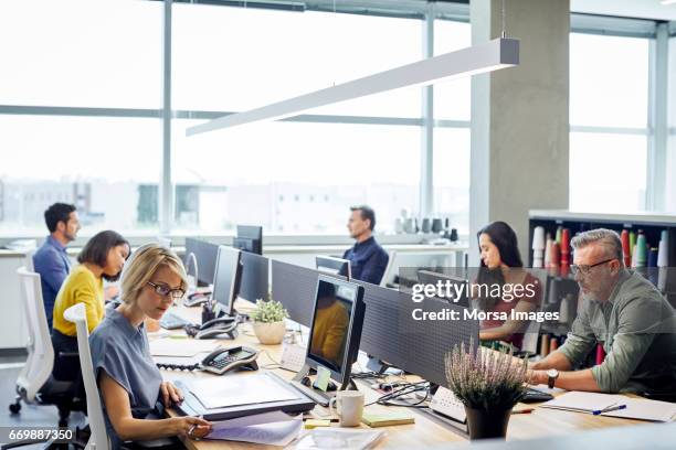 business people working at desk by windows - computer imagens e fotografias de stock