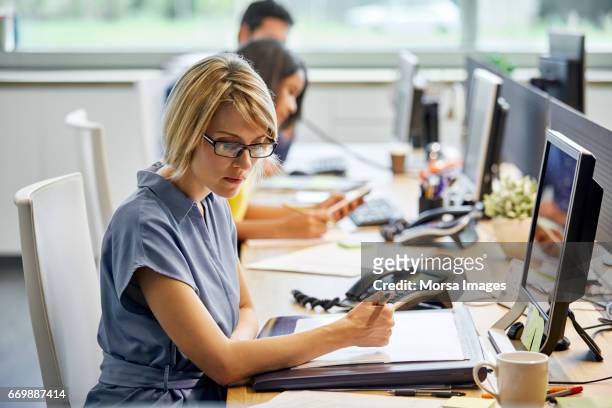 confident businesswoman working at desk - small group of people foto e immagini stock