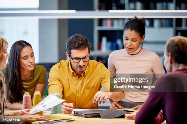 colleagues discussing over fabric swatches - textile industry stock pictures, royalty-free photos & images