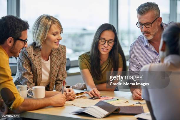 professionals discussing over fabric swatches - casual clothing stock pictures, royalty-free photos & images