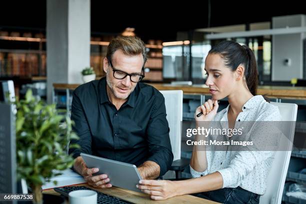 kollegen mit tablet-pc in textilfabrik - büro stock-fotos und bilder