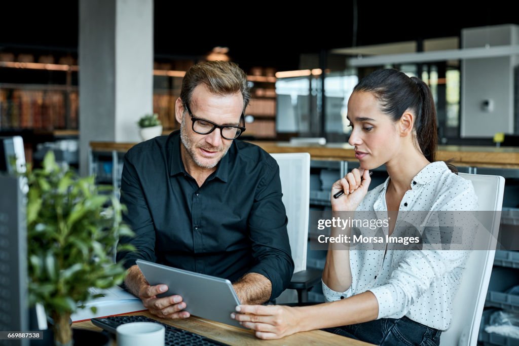 Colleagues using tablet PC in textile factory
