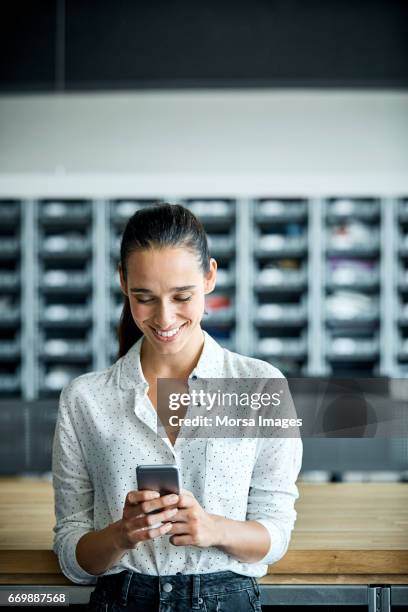 empresaria con teléfono inteligente en fábrica textil - gente mirando moviles fotografías e imágenes de stock