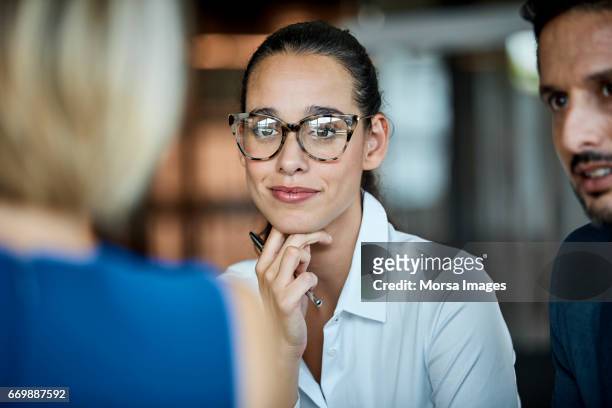 confident businesswoman looking at colleague - messa a fuoco differenziale foto e immagini stock