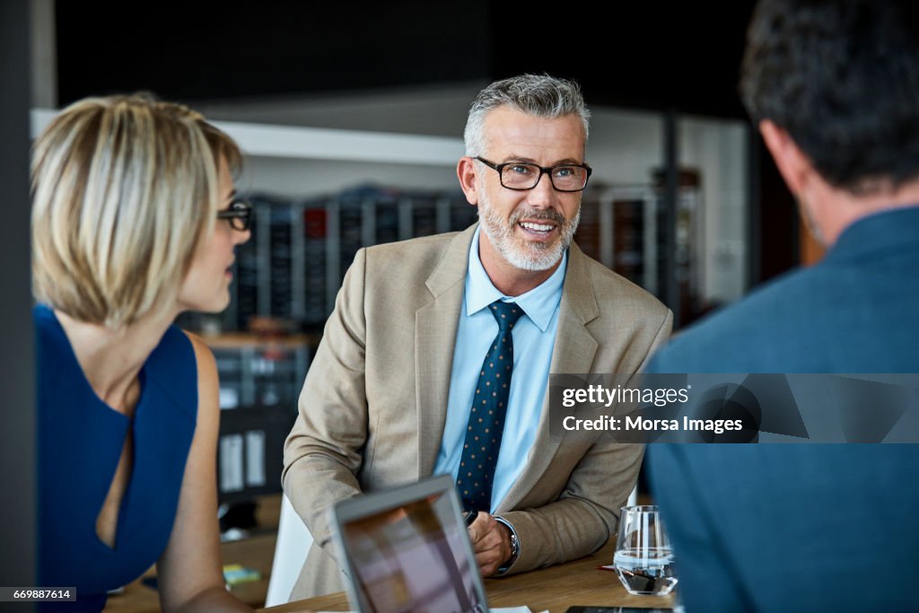 Confident businessman looking at colleague