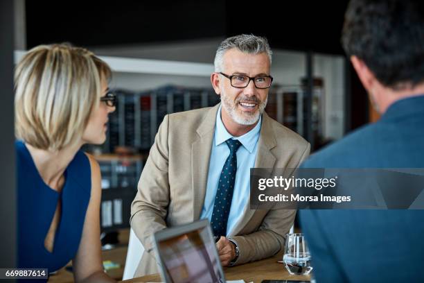 confident businessman looking at colleague - full suit stock pictures, royalty-free photos & images