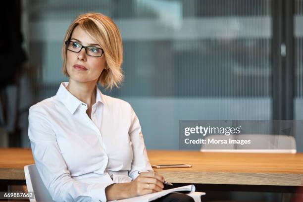 thoughtful businesswoman looking away at desk - ceo desk imagens e fotografias de stock