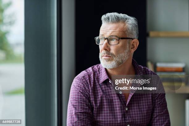 thoughtful businessman looking away in office - distrarre lo sguardo foto e immagini stock