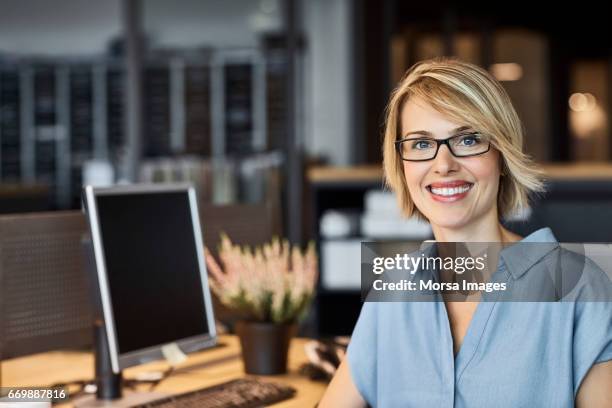 confident businesswoman smiling in office - 30s professional stock pictures, royalty-free photos & images