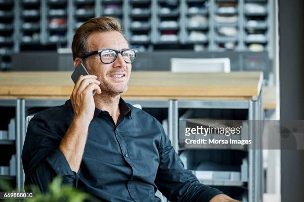 homme d’affaires à l’aide de téléphone portable dans l’usine de textile - homme d'affaires photos et images de collection