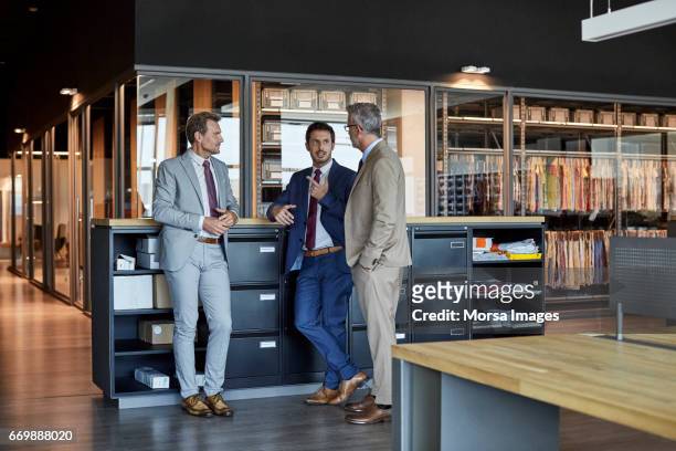 businessmen communicating in textile factory - pro to pro textile stock pictures, royalty-free photos & images
