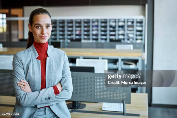 businesswoman with arms crossed in textile factory - neckline stock pictures, royalty-free photos & images