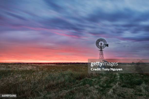 sunset falling behind a windmill. - outback windmill bildbanksfoton och bilder