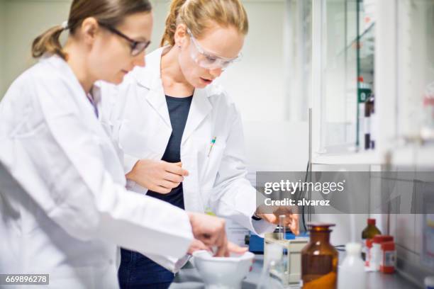 female scientists making medicine at laboratory - mortar and pestle stock pictures, royalty-free photos & images