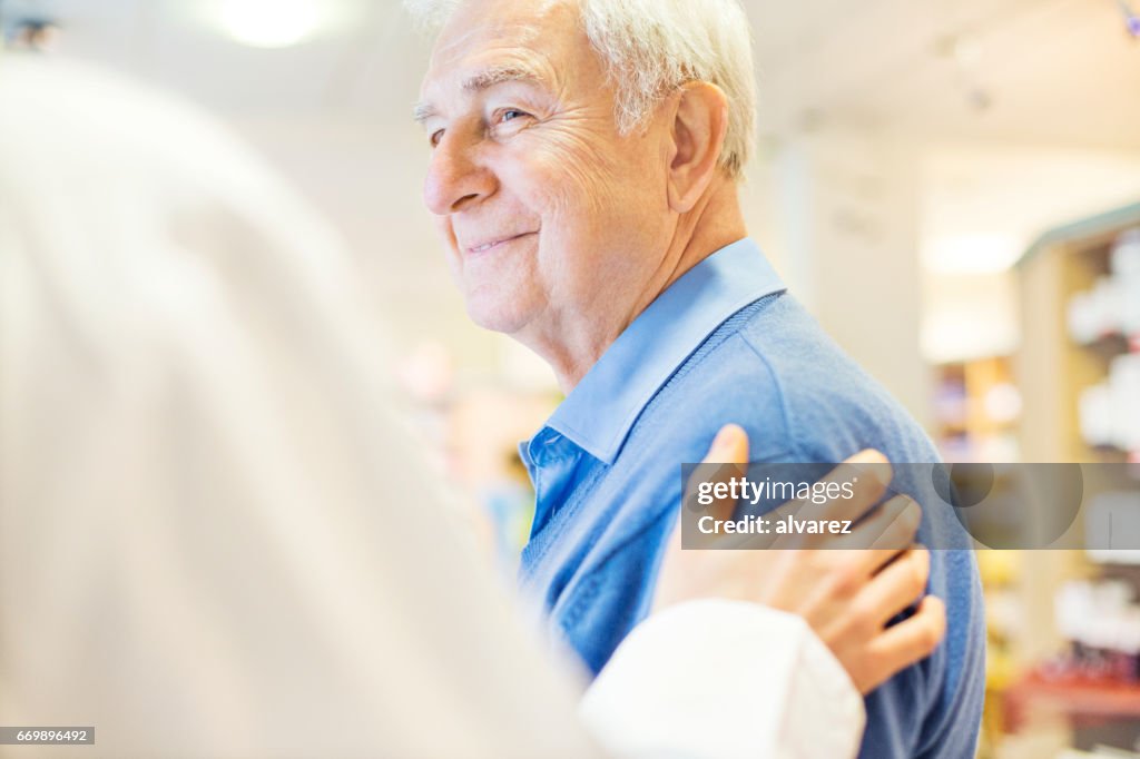 Lächelnder senior Mann Blick auf Apotheker