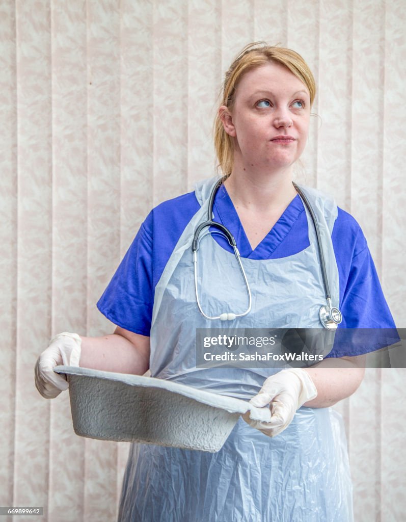 Young nurse emptying bed pan