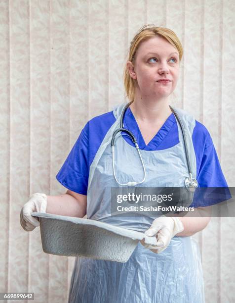 Young Nurse Emptying Bed Pan High-Res Stock Photo