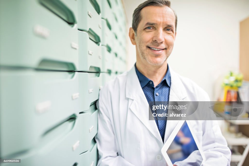 Pharmacist holding digital tablet in storage room