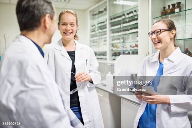 glücklich wissenschaftler sprechen im labor in apotheke - apothekerberuf stock-fotos und bilder