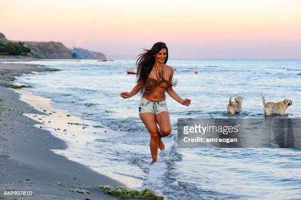 beautifu woman running on the beach - dog mid air stock pictures, royalty-free photos & images