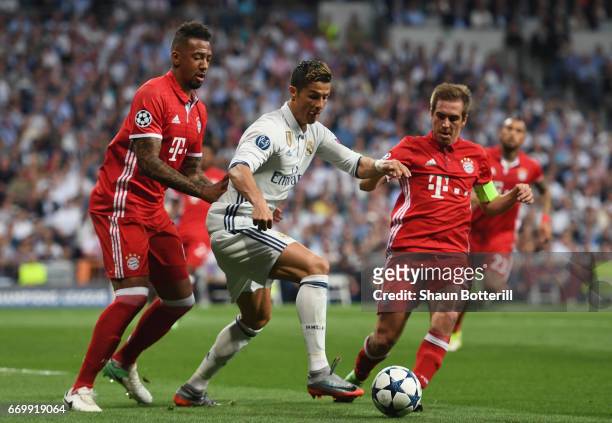 Jerome Boateng of Bayern Muenchen and Philipp Lahm of Bayern Muenchen attempt to tackle Cristiano Ronaldo of Real Madrid during the UEFA Champions...